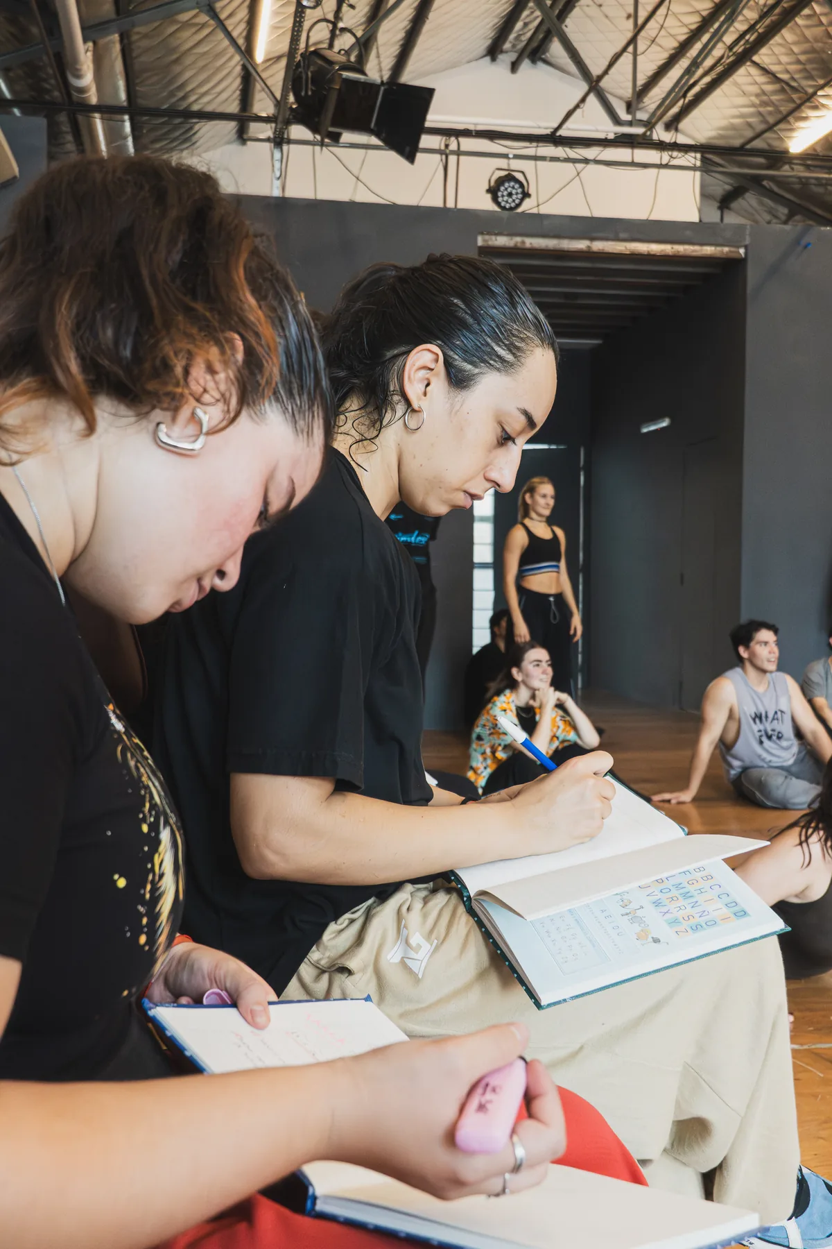 Alumnas escribiendo en sus cuadernos durante la clase